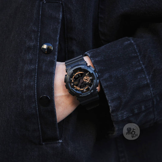 CASIO GA-110RG-1AER G-Shock 200M 防水 防震 - 手錶佩戴於手腕，深色牛仔外套袖口若隱若現